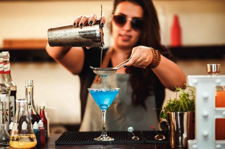 Barmanka připravující koktejl během sezónní práce v Řecku.