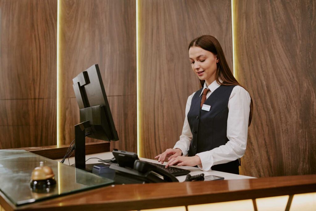 Recepční pracující na hotelové recepci během sezónní práce v Řecku