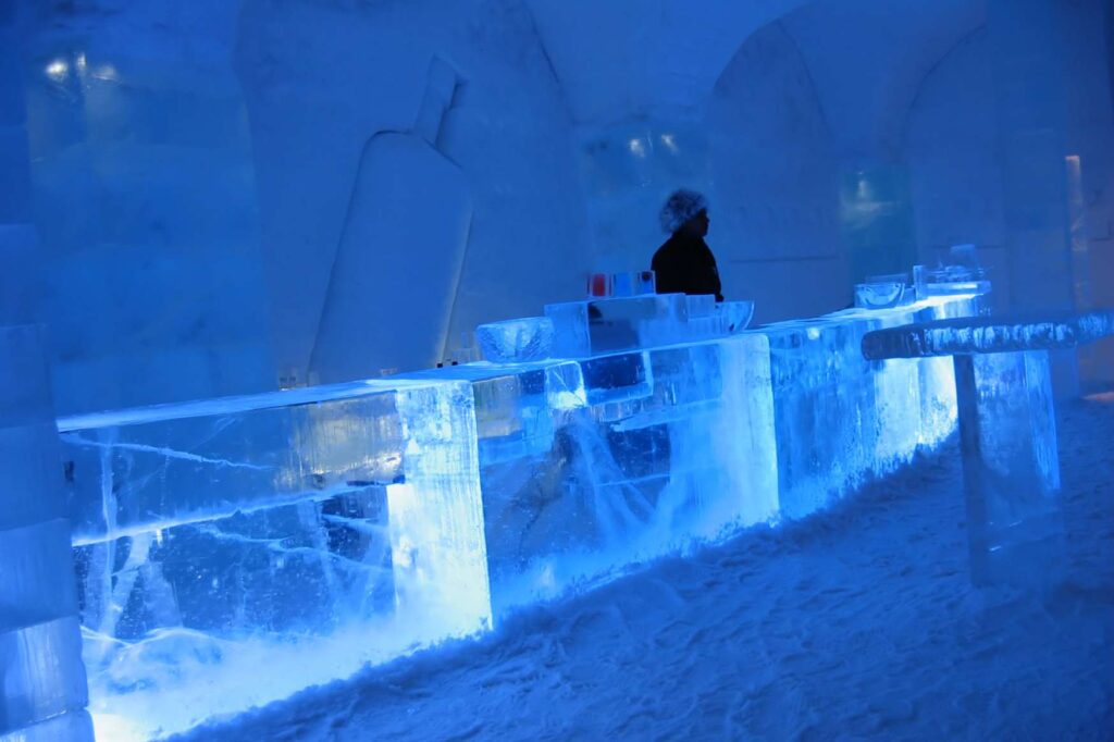 Zaměstnanec obsluhuje hosty v Icebaru v Icehotelu ve Švédsku.