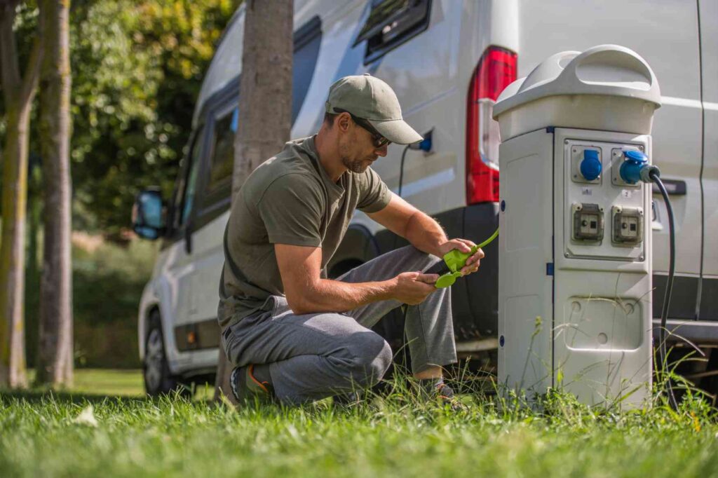 Práce v kempu v Dánsku – zaměstnanec připojuje karavan k elektrické přípojce