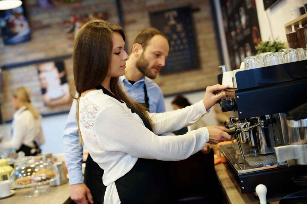Baristka připravuje kávu při práci v kavárně ve Švédsku.