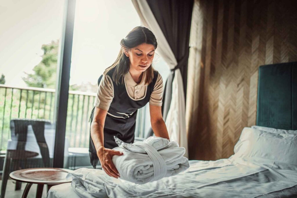 Pokojská připravuje hotelový pokoj při práci v housekeeping ve Švédsku.