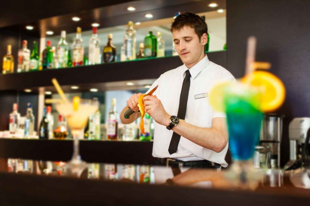 Barman připravuje koktejl za barem v hotelu na Kypru.