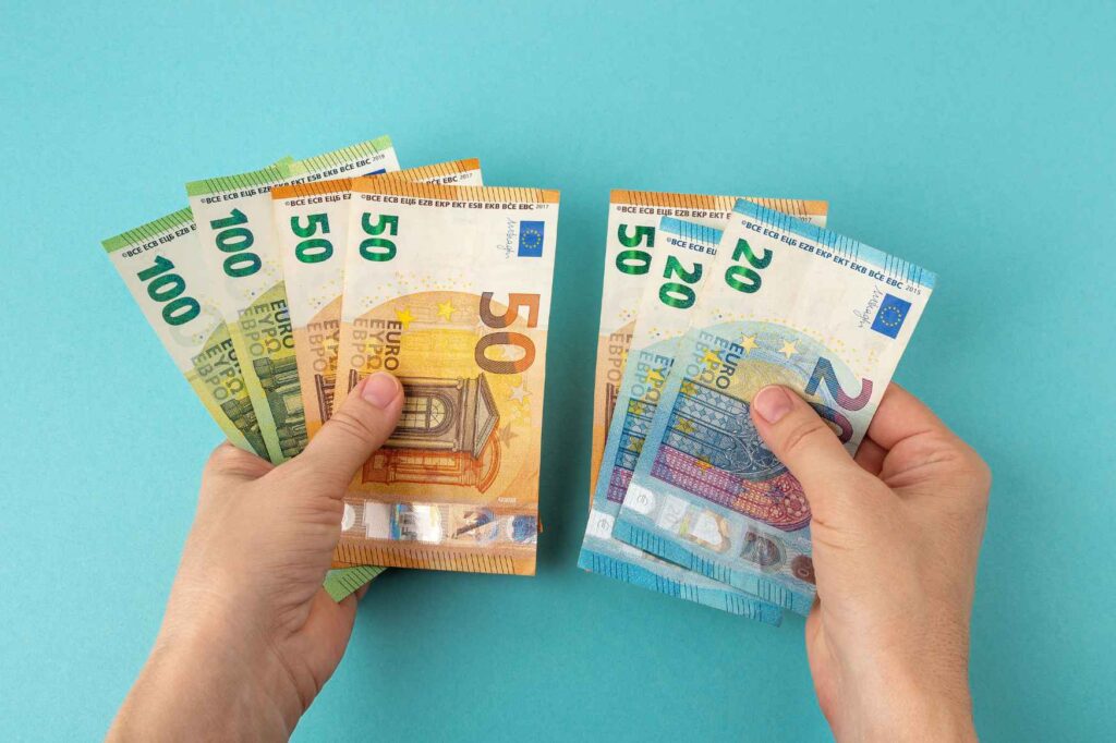 Člověk počítá eura po výplatě ze sezónní práce na Kypru.
