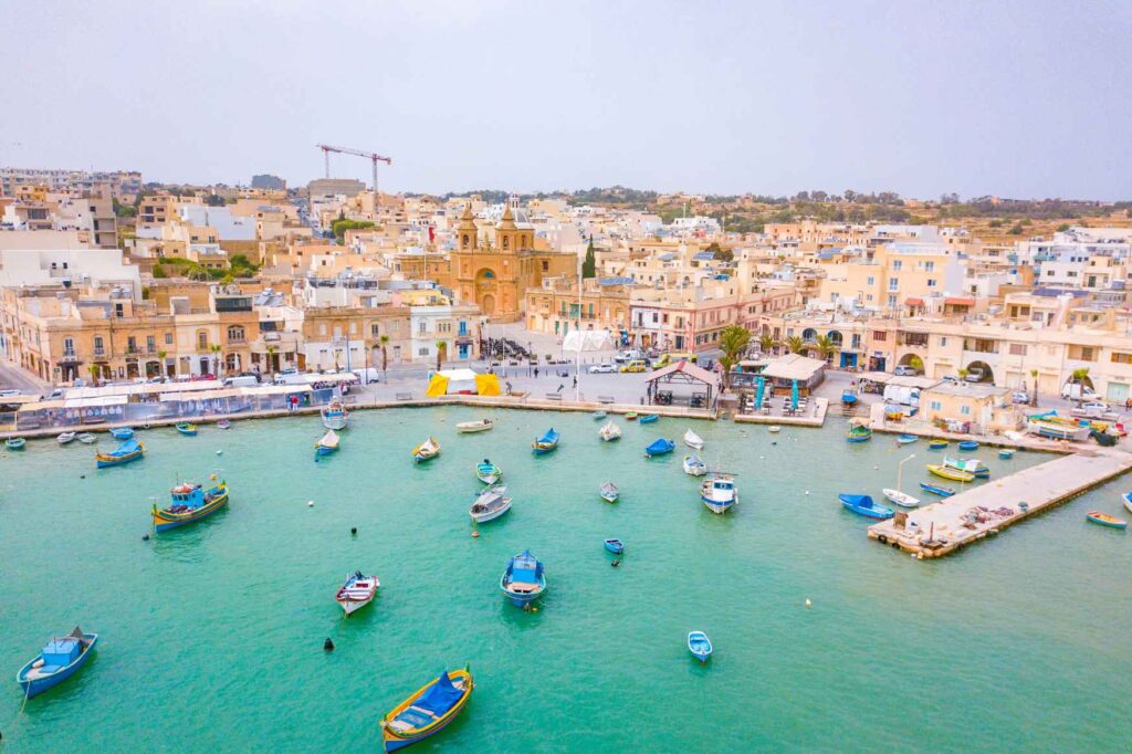 Práce na Maltě - Přístav s tradičními barevnými loděmi v Marsaxlokku