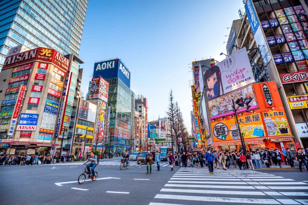 Práce v zahraničí - Rušná městská ulice s obchody a japonskými nápisy v Japonsku